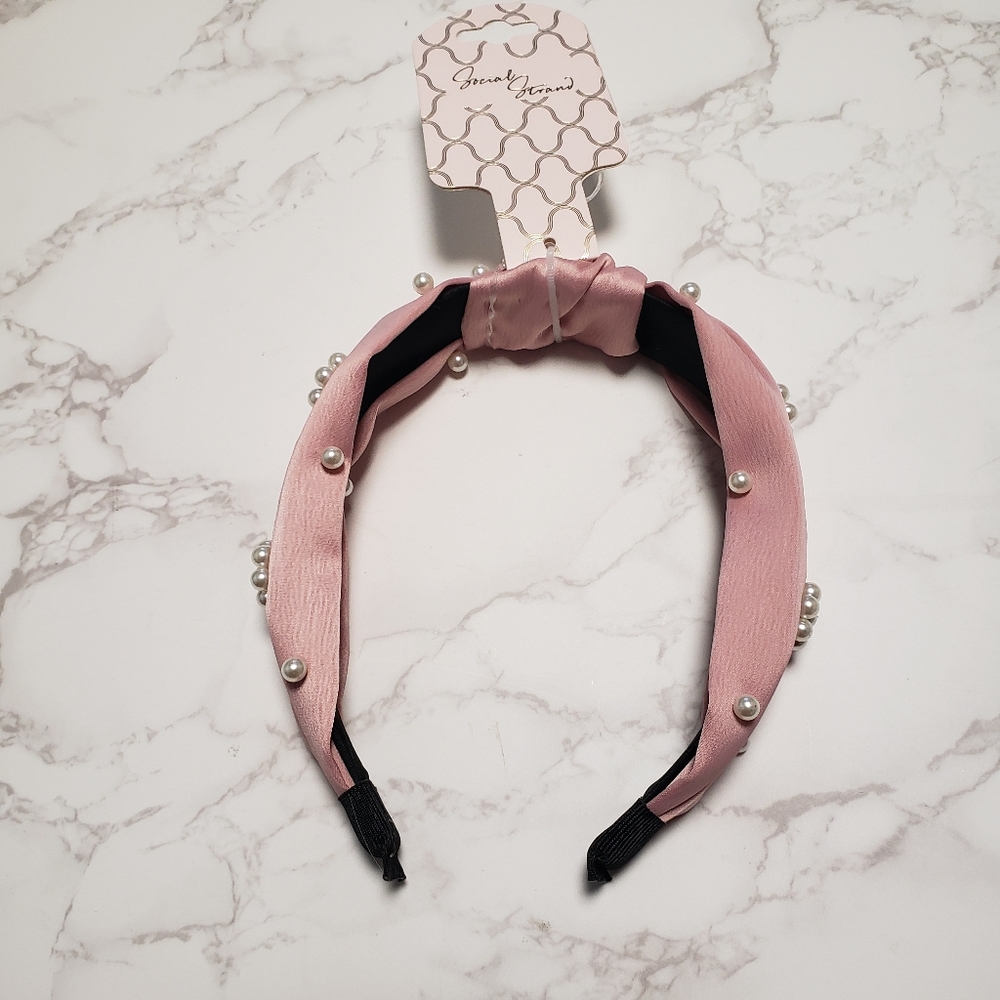 Social Strand pink and black headband embellished with pearls.